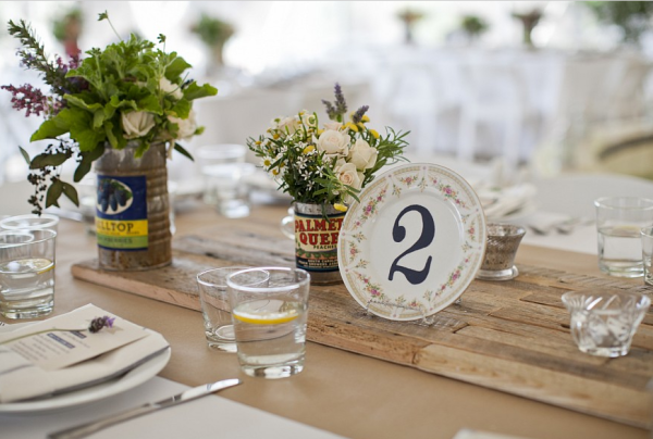Hand stenciled table numbers on mismatched china. Photo by Leah Lee.